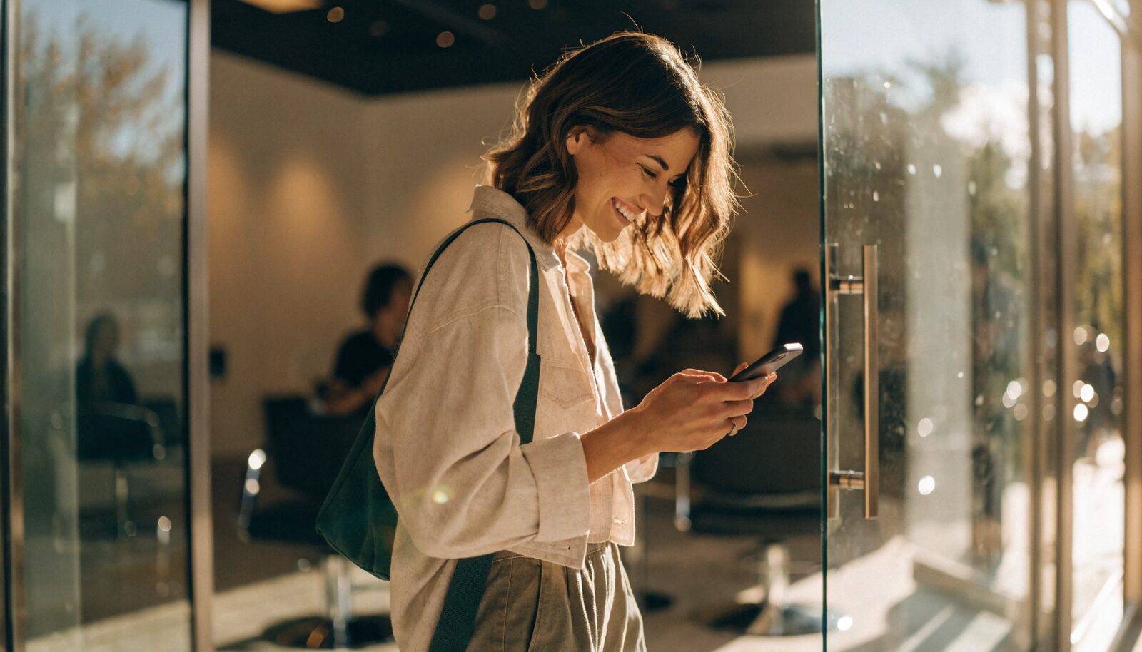Cliente soddisfatta che sorride guardando lo smartphone all'uscita del salone
